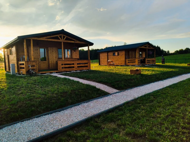 dwa drewniane domki, widok od strony werandy