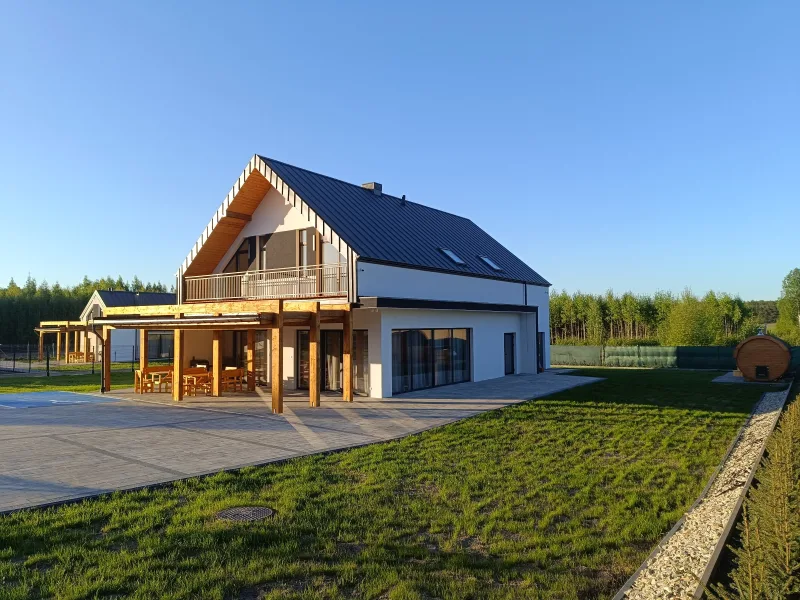 biały domek, drugi w tle, po prawej stronie balia