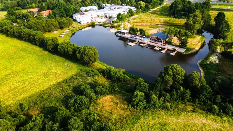 widok z lotu ptaka na pole, drzewa i kompleks hotelowy