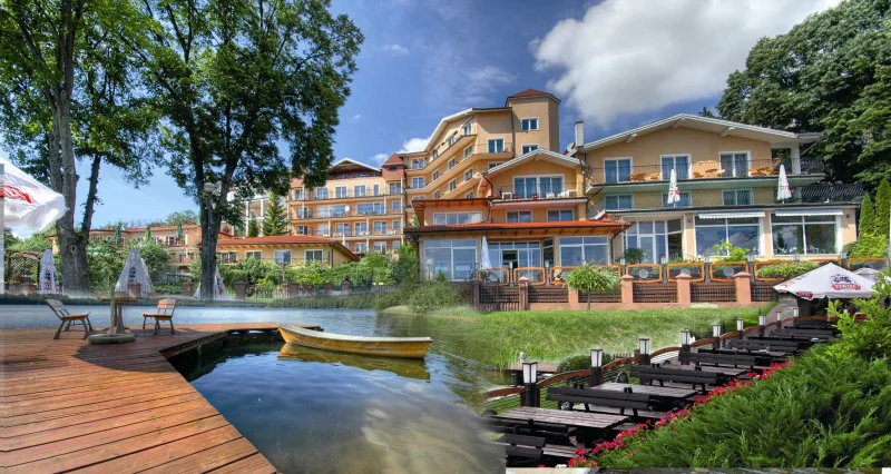 zdjęcie hotelu od strony jeziora, pomost, łódka