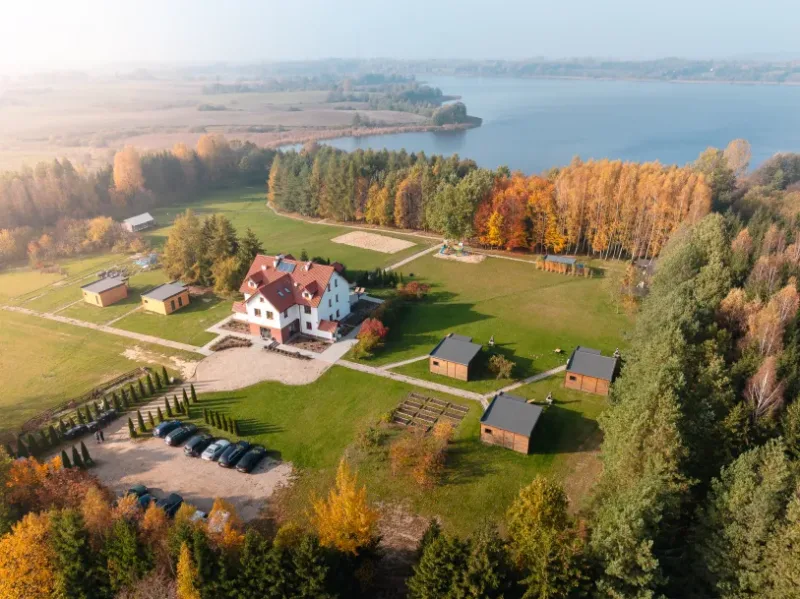 zdjęcie obiektu noclegowego, kilku domków z lotu ptaka, w tle jezioro